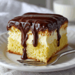 Boston Cream Poke Cake slice with pudding and chocolate ganache